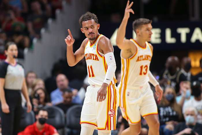 Trae Young and Bogdan Bogdanovic point to the sky after a made shot.